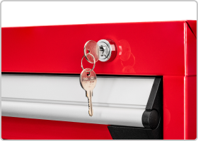 Close-up image of key on a ring in the lock of a red tool cabinet. Another key is hanging from the ring.